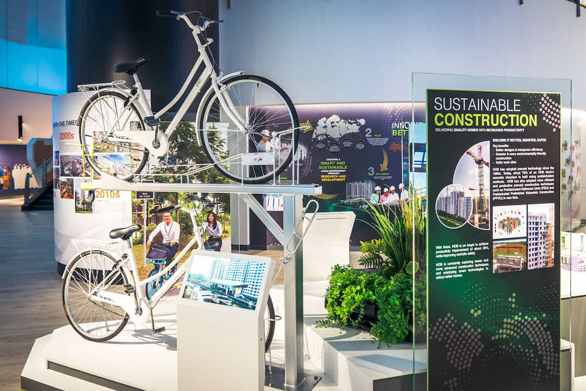 Exhibition panels and a dual-bicycle rack showing HDB's efforts to make towns more sustainable.